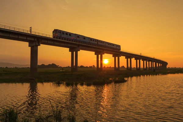 Bir tren Köprüsü günbatımı zamanı geçiyor