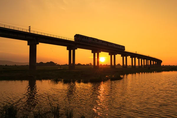 A train is crossing bridge in sunset time