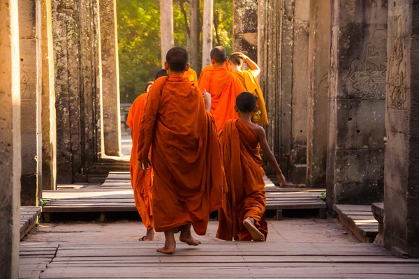 I monaci nelle antiche facce di pietra del tempio di Bayon, Angkor Fotografia Stock