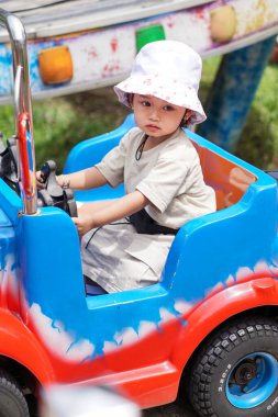 Çocuk parkında oyuncak araba kullanan tatlı çocuk..