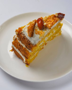 Karamelli ve fındıklı balkabağı katlı kekin yakın çekimi. Mevsimlik karamel şuruplu sonbahar pastası çay için tatlı tatlı ya da beyaz arka planda kahve zamanı..