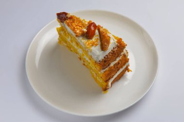 Karamelli ve fındıklı balkabağı katlı kekin yakın çekimi. Mevsimlik karamel şuruplu sonbahar pastası çay için tatlı tatlı ya da beyaz arka planda kahve zamanı..