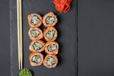 Farklı suşi dürümleri, peynirli suşi seti. Kaliforniya suşi ruloları siyah tebeşir tahtasında servis edilir. Japon mutfağı kavramı.