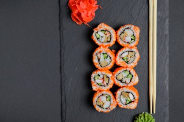 Farklı suşi dürümleri, peynirli suşi seti. Kaliforniya suşi ruloları siyah tebeşir tahtasında servis edilir. Japon mutfağı kavramı.