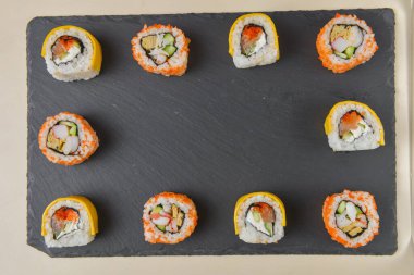 Farklı suşi dürümleri, peynirli suşi seti. Kaliforniya suşi ruloları siyah tebeşir tahtasında servis edilir. Japon mutfağı kavramı.