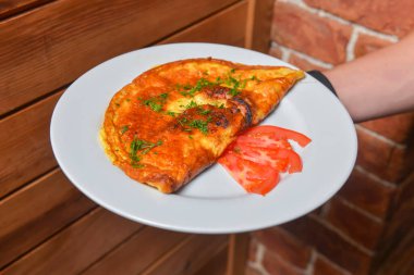 Çırpılmış yumurta ve taze otlar beyaz tabakta. Sebzeli lezzetli omlet. Restoranda sabah kahvaltısı servisi yapan garson. Konsept yemek, lezzetli yemek..