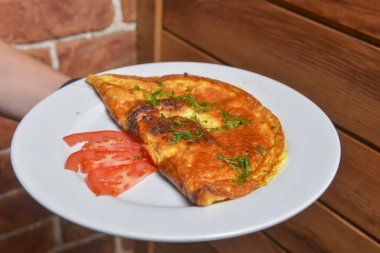 Çırpılmış yumurta ve taze otlar beyaz tabakta. Sebzeli lezzetli omlet. Restoranda sabah kahvaltısı servisi yapan garson. Konsept yemek, lezzetli yemek..
