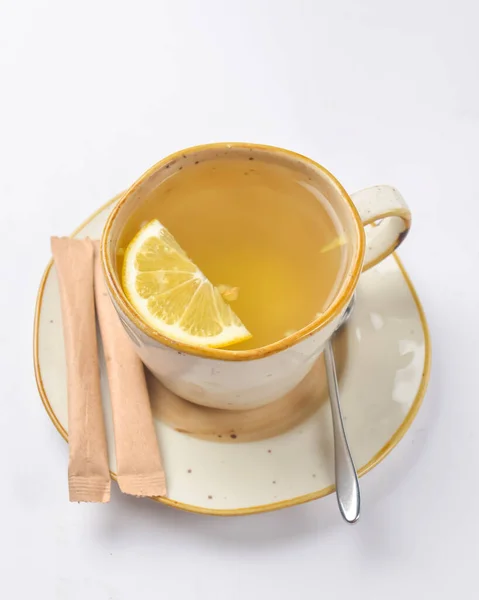 Tea in cup with piece of lemon isolated on white background. Hot tea for cold weather. Copy space banner.