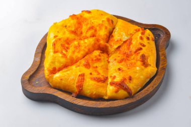 Beyaz arka planda tahtanın üzerinde peynir ve yumurta olan Khachapuri. Gürcistan mutfağı konsepti, kapat.