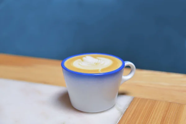 Coffee cup with coffee foam on wooden table. Latte coffee in restaurant or cafe, eating out concept, coffee concept. Copy space banner.