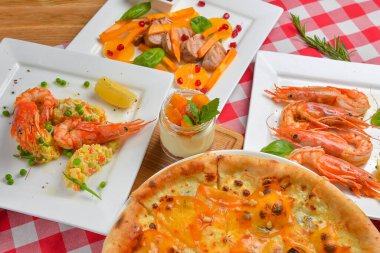 İtalyan mutfağı konsepti düz, manzaralı. Hurma menüsü, pizza, karides, salata, tatlı. Sonbahar kış yemeği konsepti.