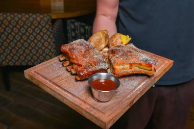 Restoranda ya da lokantada ızgara domuz pirzolası servis ediliyor. Garson servisi, dışarıda yemek konsepti. Yemek için lezzetli bir fikir..