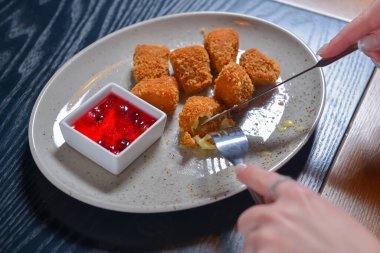 Kızarmış camembert peyniri ve kızılcık sosu beyaz tabakta servis ediliyor. Hayat, dışarıda yemek kavramı..