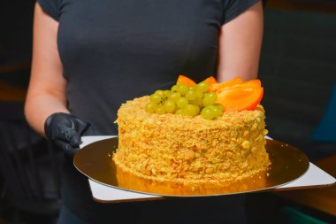 Napolyon 'un tüm keki, garsonun servis ettiği kafe ya da restoranda. Doğum günü partisi kutlaması, dışarıda yemek konsepti, servis.