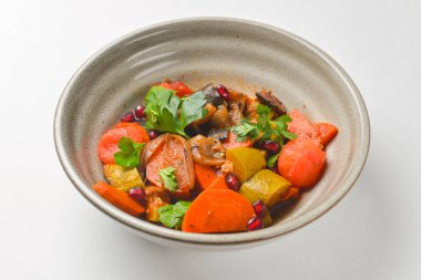 Beyaz arka planda seramik kasede fırında sebze salatası. Lezzetli sağlıklı sonbahar ya da kış salatası.