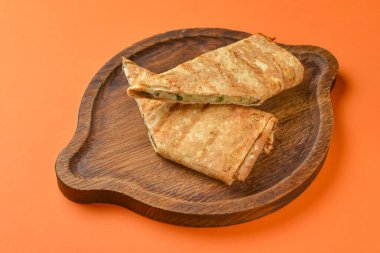 Lavaş ve suluguni peyniri. Lezzetli çerez. Turuncu arka planda ahşap bir tahtada servis edilmiş..