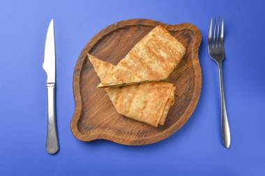 Lavaş ve suluguni peyniri. Lezzetli çerez. Mavi arka planda tahta bir tahtada servis edilmiş..