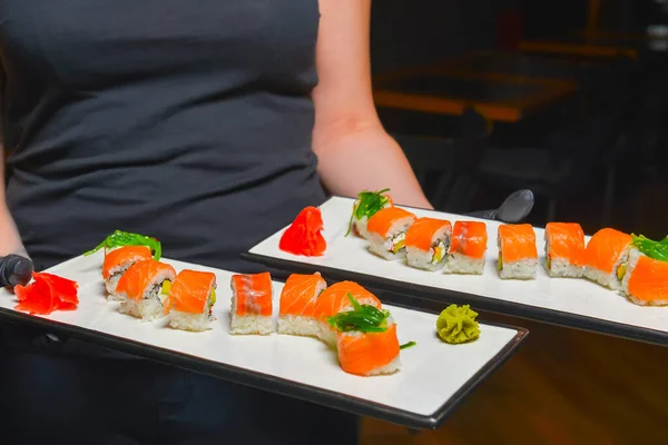 Rollos de sushi de salmón y caviar servidos en un plato en un restaurante o restaurante. Servicio de camarero, concepto para la cena. — Foto de Stock