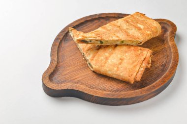 Lavaş ve suluguni peyniri. Lezzetli çerez. Beyaz arka planda ahşap bir tahtada servis edilmiş. Kapat..