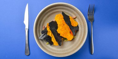 Etli taze salata, marul ve domates, salatalık, kızarmış ekmek. Mavi arka planda seramik bir kasede servis edilmiş. Akşam yemeği için lezzetli bir yemek. İzole edilmiş.