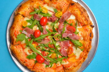 Mavi arka planda izole edilmiş bir Pepperoni pizza. Geleneksel İtalyan mutfağı konsepti, pizza Margarita veya Margherita üzeri mavi..