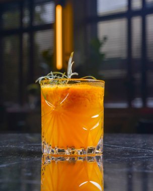 Elma suyu, buz ve tarçınlı kokteyl siyah bir masada küçük bir bardakta. Restoran konseptinde dışarıda yemek yemek. Parti için nefis alkol içecekleri..