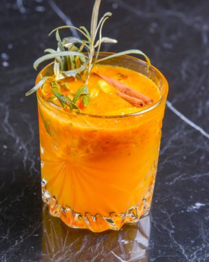 Elma suyu, buz ve tarçınlı kokteyl siyah bir masada küçük bir bardakta. Restoran konseptinde dışarıda yemek yemek. Parti için nefis alkol içecekleri..