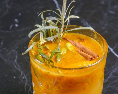 Elma suyu, buz ve tarçınlı kokteyl siyah bir masada küçük bir bardakta. Restoran konseptinde dışarıda yemek yemek. Parti için nefis alkol içecekleri..