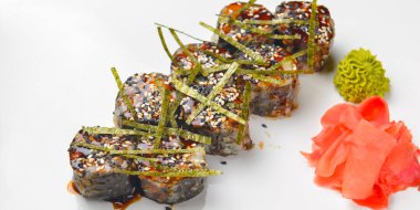 Beyaz tabakta zencefil ve wasabi turşulu unagi soslu büyük bir suşi seti. Geleneksel Japon mutfağı kavramı.