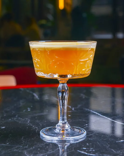 ブラックテーブルのユニークなガラスの中で新鮮な情熱のフルーツオレンジドリンク レストランのコンセプトで外食 パーティー用アルコール飲料 — ストック写真