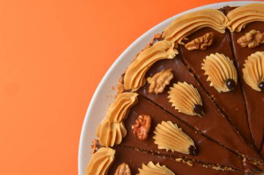 Üstü kremalı çikolatalı pasta ve fındıklı renkli arka plan. Çay ya da kahve saati için lezzetli çikolatalı pasta..