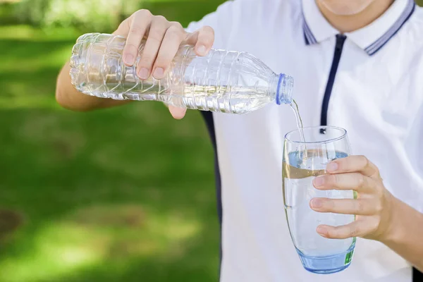 Joven Chico Caucásico Vertiendo Agua Mineral Fresca Transparente Una Botella — Foto de Stock