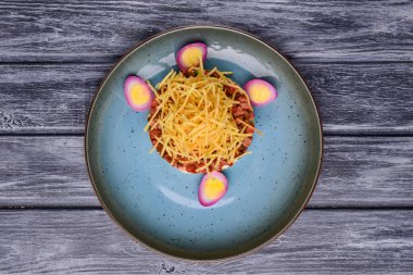 Geleneksel Rus salatası Olivier, ahşap arka planda mavi bir tabakta servis ediliyor. Geleneksel tarif, Rus ya da Ukrayna mutfağı.