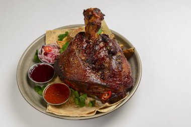 A top steak grilled on a barbecue, served on a plate with two different kinds of sauce over white background. BBQ concept.