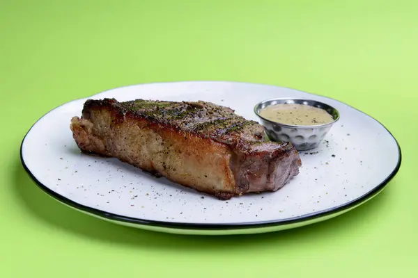 Bife Delicioso Com Molho Servido Prato Branco Sobre Fundo Verde — Fotografia de Stock