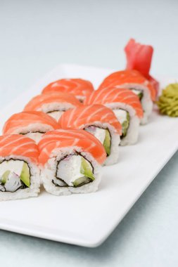 Maki Suşi, füme somon ve krem peynirden yapılmış rulo. Geleneksel Japon mutfağı kavramı, beyaz arka planda. Geleneksel tarif.