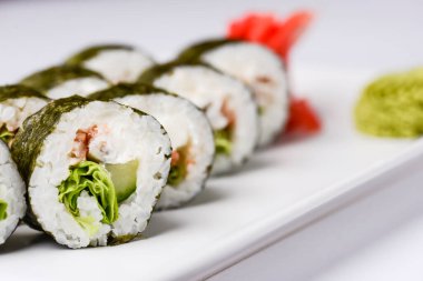 Maki Suşi, füme somon ve krem peynirden yapılmış rulo. Geleneksel Japon mutfağı kavramı, beyaz arka planda. Geleneksel tarif.