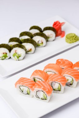 Maki Suşi, füme somon ve krem peynirden yapılmış rulo. Geleneksel Japon mutfağı kavramı, beyaz arka planda. Geleneksel tarif.