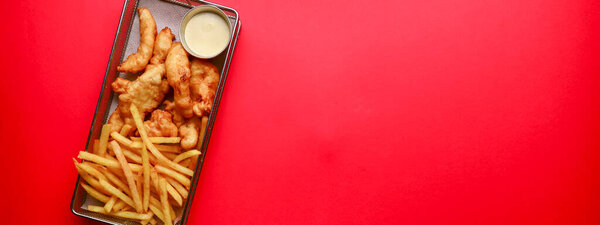 Металлический поднос куриных наггетсов с картошкой фри на ярко-красном фоне. Фастфуд, фастфуд. Закрывай. Баннер с местом для копирования текста.
