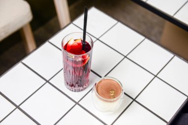 Bir yaz restoranında iki meyve kokteyli tatlısı. Tatlı çikolatalı vanilyalı tatlı ve büyük bardakta meyve suyu. Kapat..