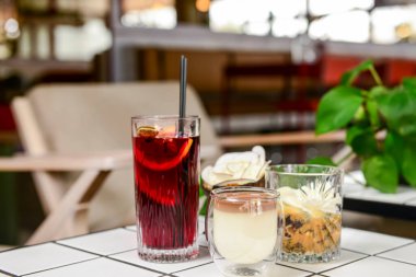 Bir yaz restoranında iki meyve kokteyli tatlısı. Tatlı çikolatalı vanilyalı tatlı ve büyük bardakta meyve suyu. Kapat..