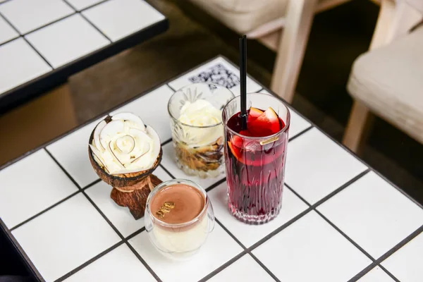 Bir yaz restoranında iki meyve kokteyli tatlısı. Tatlı çikolatalı vanilyalı tatlı ve büyük bardakta meyve suyu. Kapat..