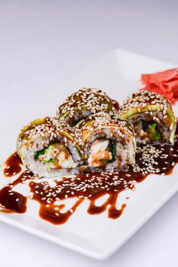 Beyaz arka planda sunulan unagi soslu yılan balığı, somon balığı ve ton balığı. Geleneksel Japon mutfağı, Asya mutfağı kavramı.