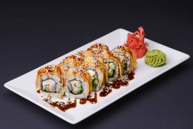 Yılanbalığı, somon balığı ve unagi soslu ton balığı siyah arka planda beyaz tabakta servis edilir. Geleneksel Japon mutfağı, Asya mutfağı kavramı.