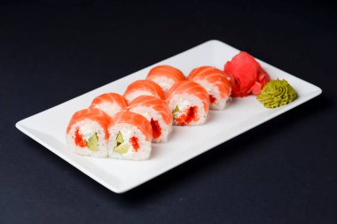 Suşi büyük seti beyaz arka planda beyaz bir tabakta servis edilir. Geleneksel Asya Japon mutfağı konsepti, kapatın..