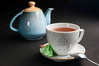 Siyah arka planda çay fincanı. Çay saati yakın..