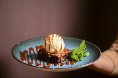 Lokantada ya da kafede garson tarafından servis edilen dondurmalı Brownie tatlısı. Lezzetli çikolatalı tatlı. Amerikan tarifi.