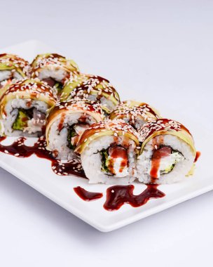 Beyaz arka planda beyaz bir tabakta servis edilen suşi küçük seti. Geleneksel Asya Japon mutfağı konsepti, kapatın..