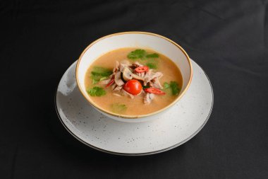 Tavuk çorbasından mantar çorbası, mantar mantarı, siyah arkaplanda beyaz bir kasede servis edilen vişneli domates. Yemek konsepti, sağlıklı sıcak çorba..