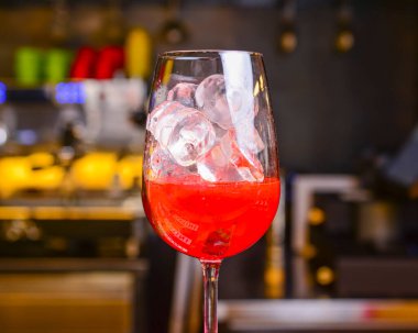 Meyve kokteyli içeceğini tazeliyorum. Siyah masanın üzerinde limon ve bulanık geri grond var. Restoranda ya da kafede, dışarıda yemek konsepti..